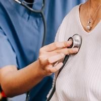A doctor listening to a patients heart