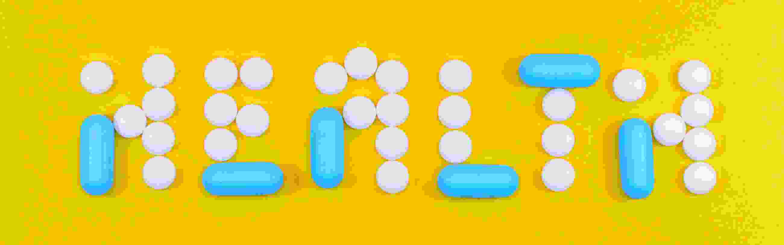 Blue and white pills arranged to spell the word "health"