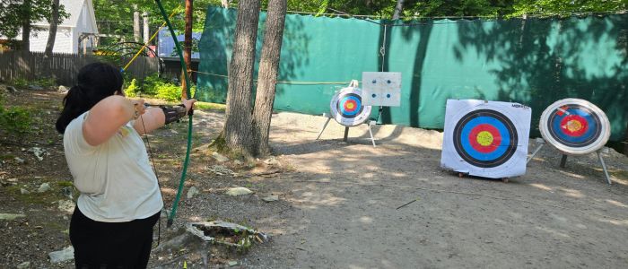 Jenna shooting archery at camp