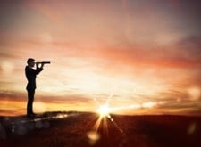 photo of silhouette of person peering thorugh a handheld telescope, sun setting in background