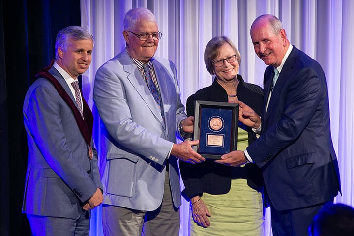 Andres Schanzer is joined by donors Bruce Cutler and Kim Cutler and Chancellor Michael F. Collins at the annual Convocation and Investiture ceremony in September 2023.