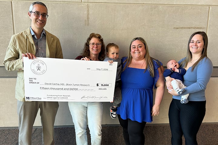 The family of Roland Card, including wife Kathy and daughters, Nicole and LeeAnn, present a check to David Cachia, MD.