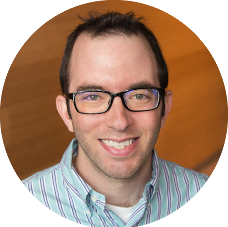 Circular portrait of Dr. Matthew Schwartz, who has short black hair and glasses and is wearing a striped button-down shirt and smiling.