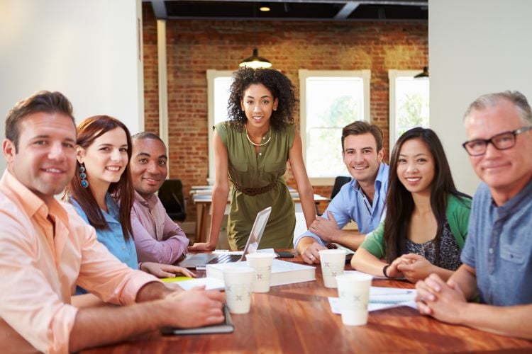 group sitting around a boardroom table looking at the camera