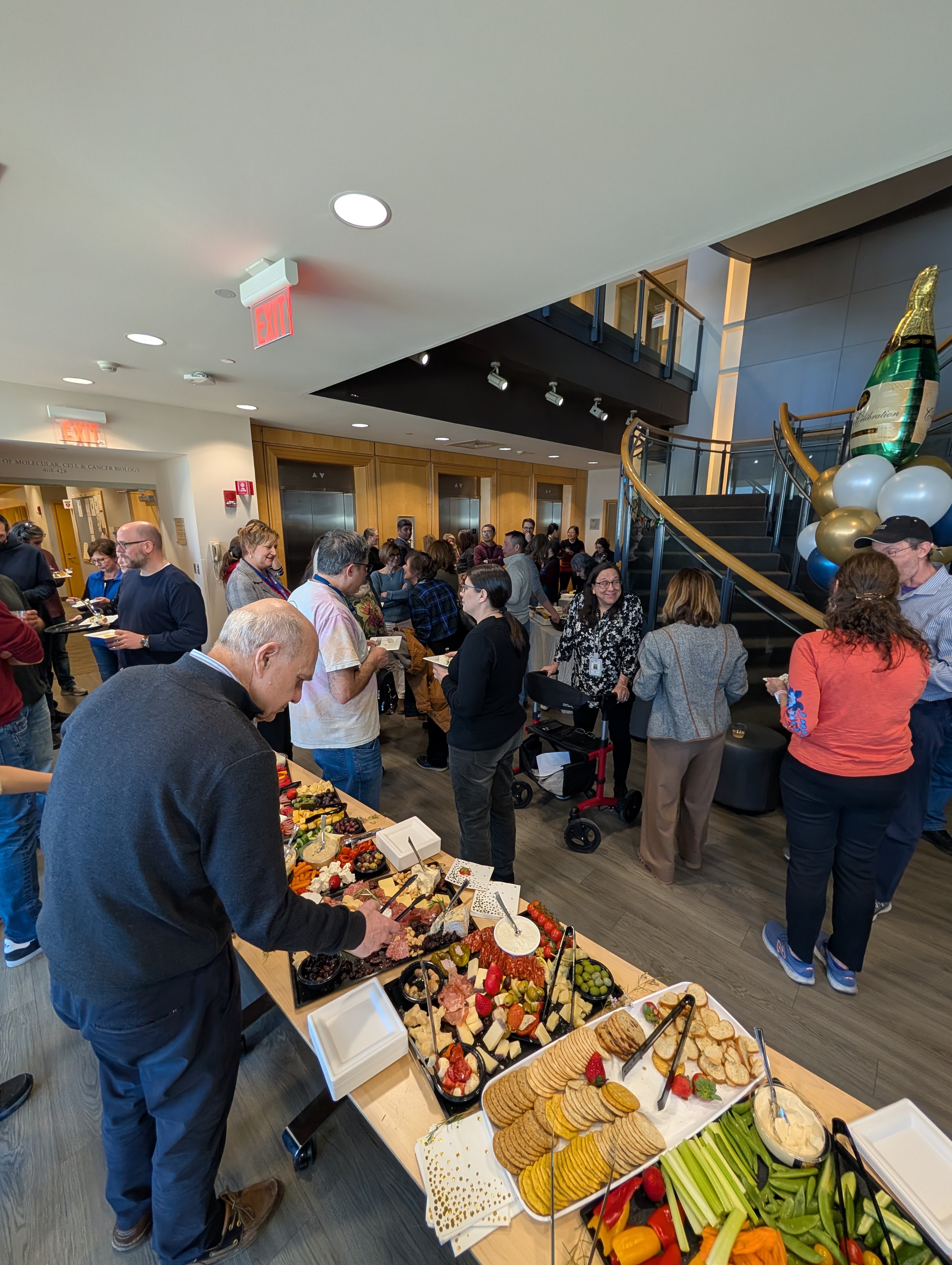 Candid photo of attendees socializing and talking at a retirement party.