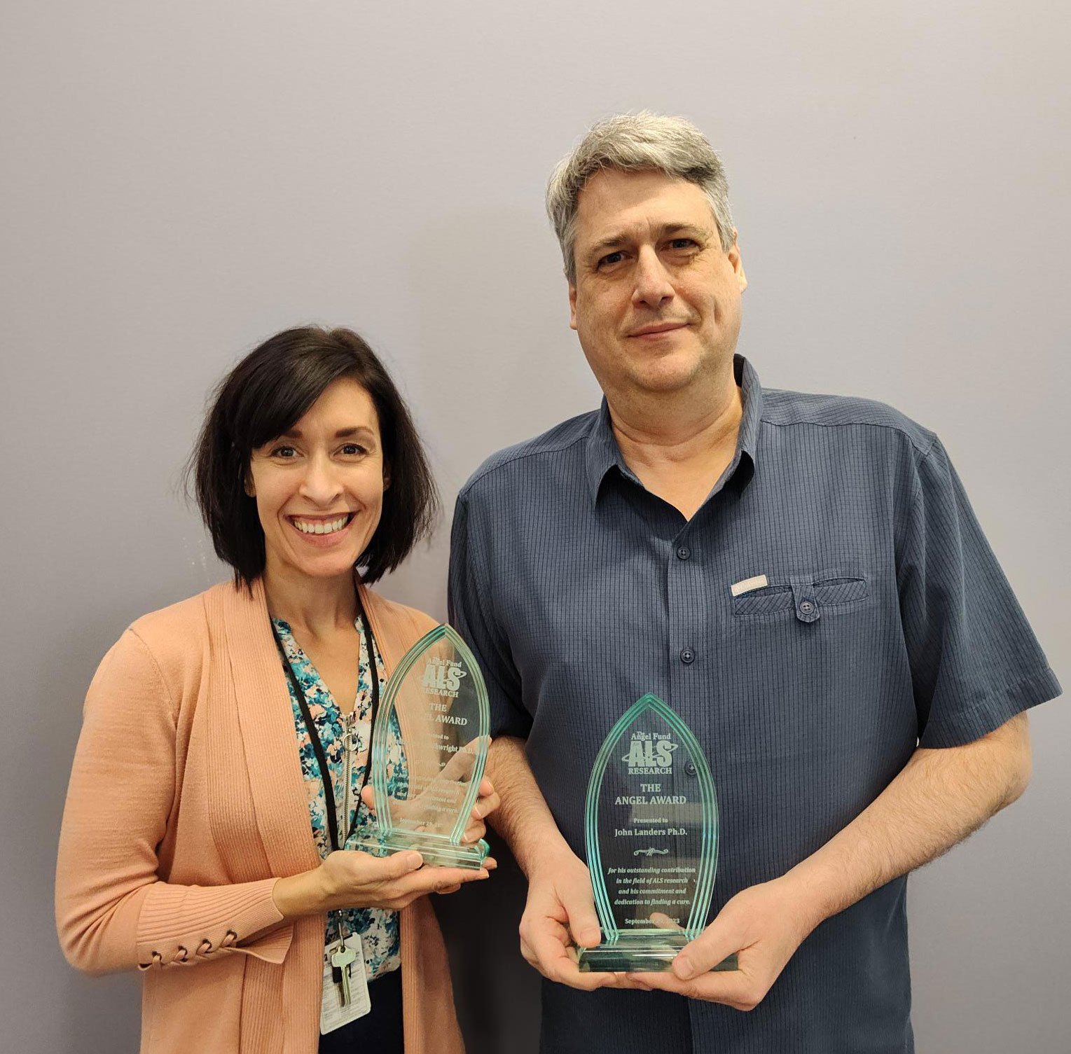 Catherine Douthwright and John Landers holding recognition plaques from The Angel Fund