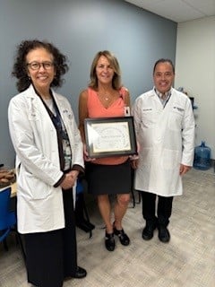 Andrea Husereau holding certificate with AM Barrett and Brian Silver