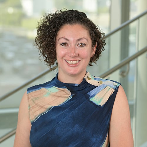 white woman with dark curly short hair smiling