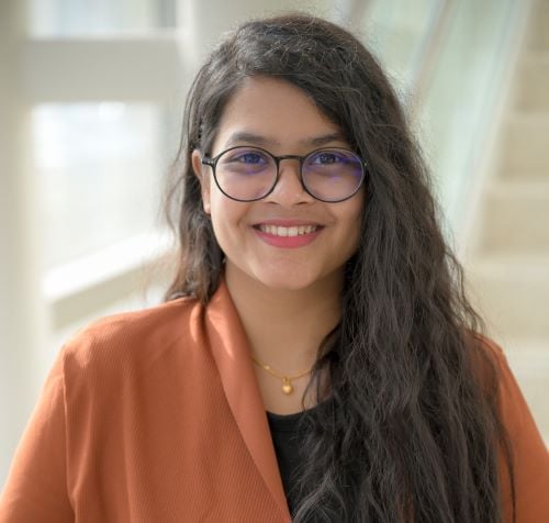 indian woman with long dark wavy hair and glasses