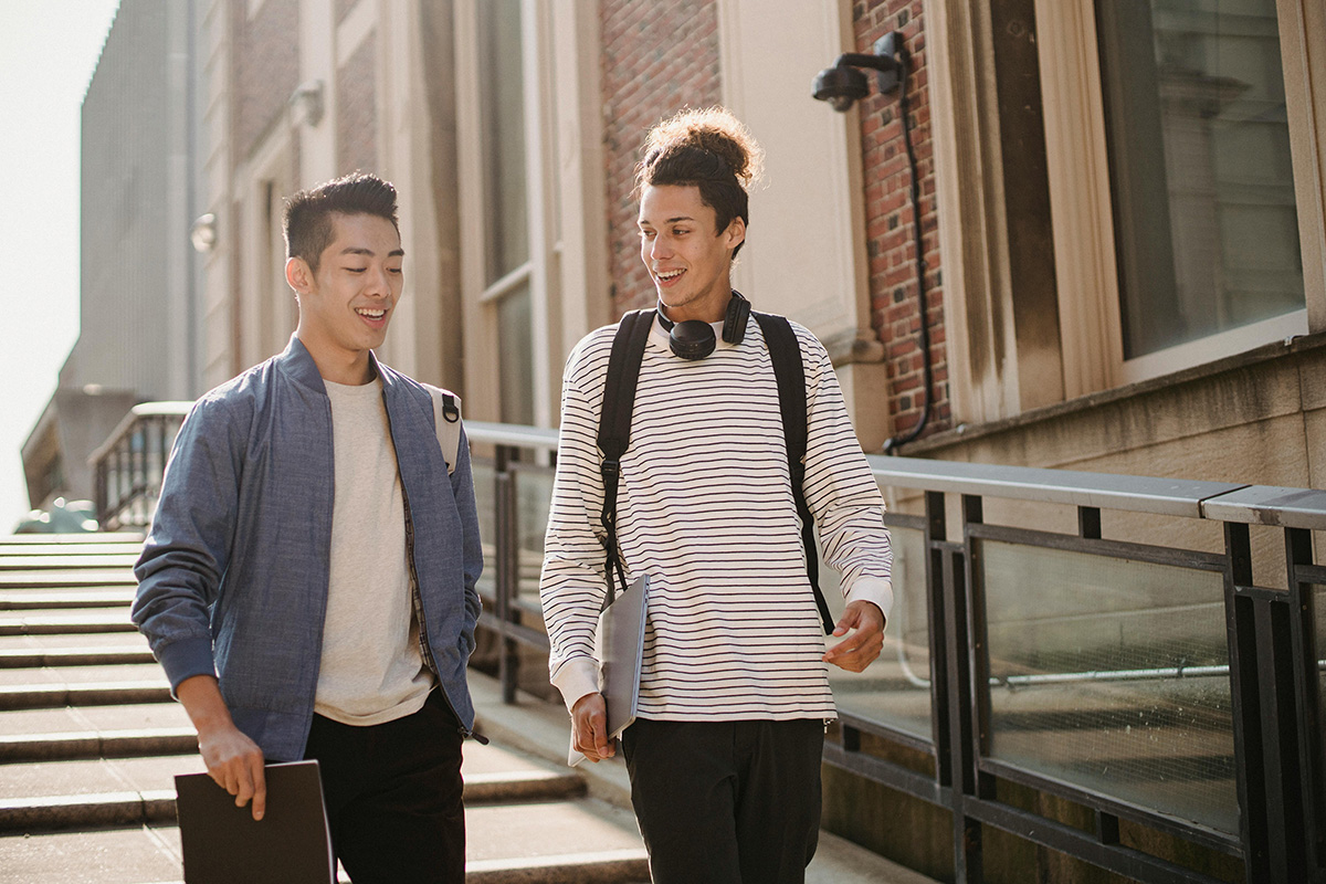 two men outside walking and talking