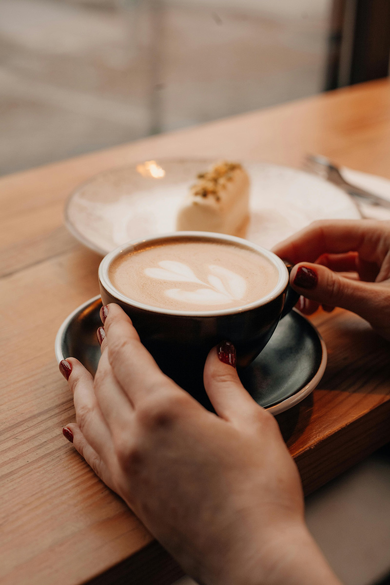 unseen person holding cup of coffee