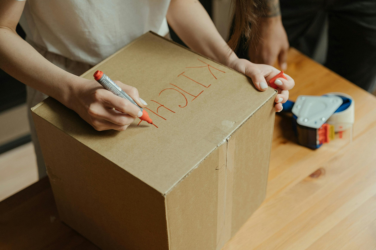 person labeling a moving box