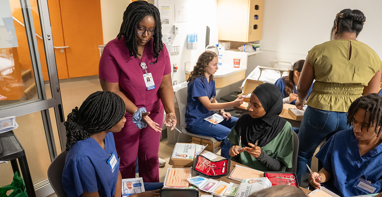 : Fourth-year T.H. Chan School of Medicine student Vanessa Urhiafe helps lead the suturing learning station