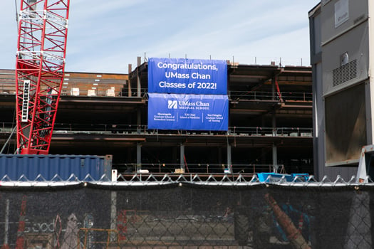 Overlooking the UMass Chan campus green is the frame of the new education and research building, scheduled for completion in 2024.