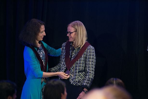 Tiffany Moore Simas, MD, MPH, presents Heather Forkey with the medal for the Joy McCann Professor for Women in Medicine.