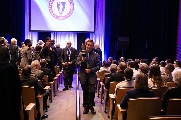 Dr. Baldor carries the mace from the ceremony.