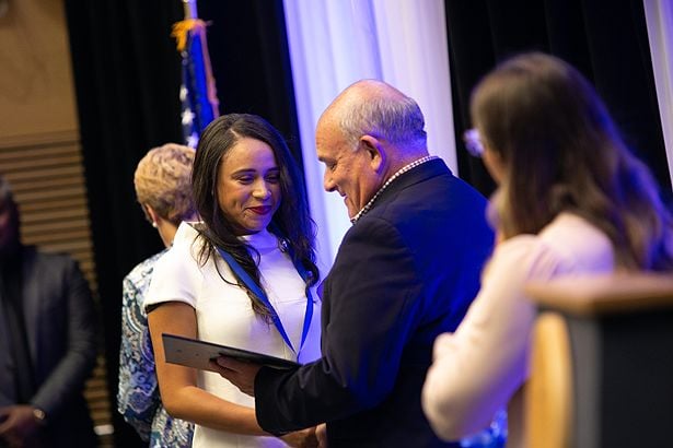 Daniela Carrasco receives her certificate from James Fain, PhD, associate dean for inter professional and community partnerships.