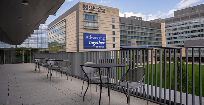 Outdoor patio with tables and chairs overlooking the campus green