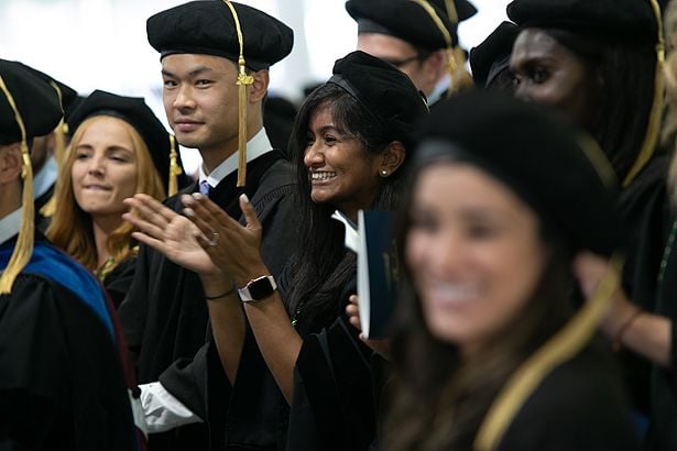 Sana Majid of the School of Medicine applauds her classmates.