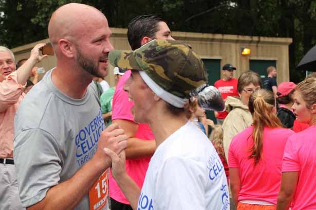 Kate Cellucci crosses the finish line and is congratulated by Spencer Fortwengler, coach of the Hudson High School girls track & field team.