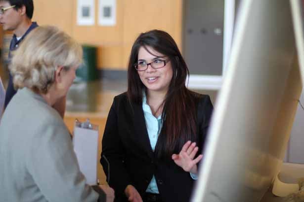 Savannah State University junior Tiffany Villanueva confers with judge Zdenka Matijasevic, PhD, assistant professor of cell & developmental biology.