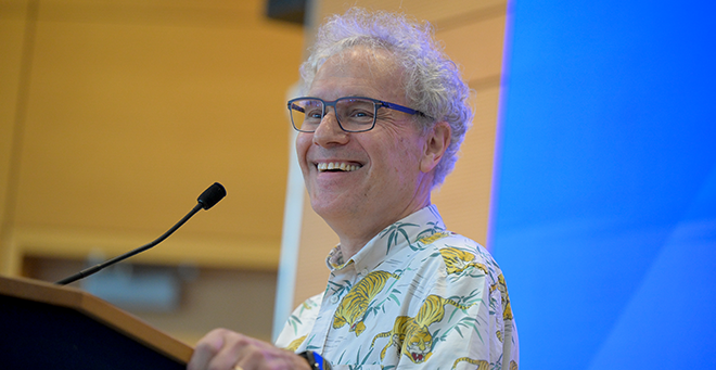 Victor Ambros speaking at a podium 