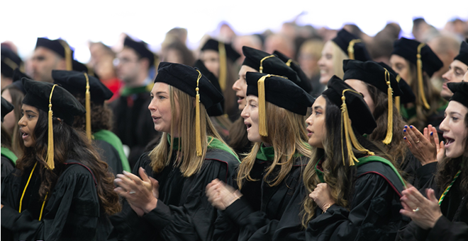 UMass Chan Medical School graduates sitting under a tent