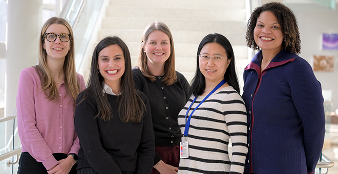 Melissa Goulding, Elise Stevens, Grace Ryan, Chan Zhou, and Sarah Forrester stand together in front of a staircase